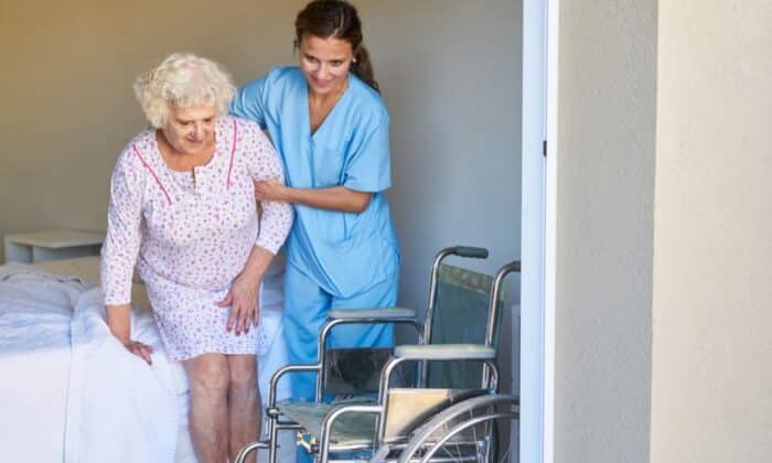 Une infirmière aidant une personne âgée à se lever
